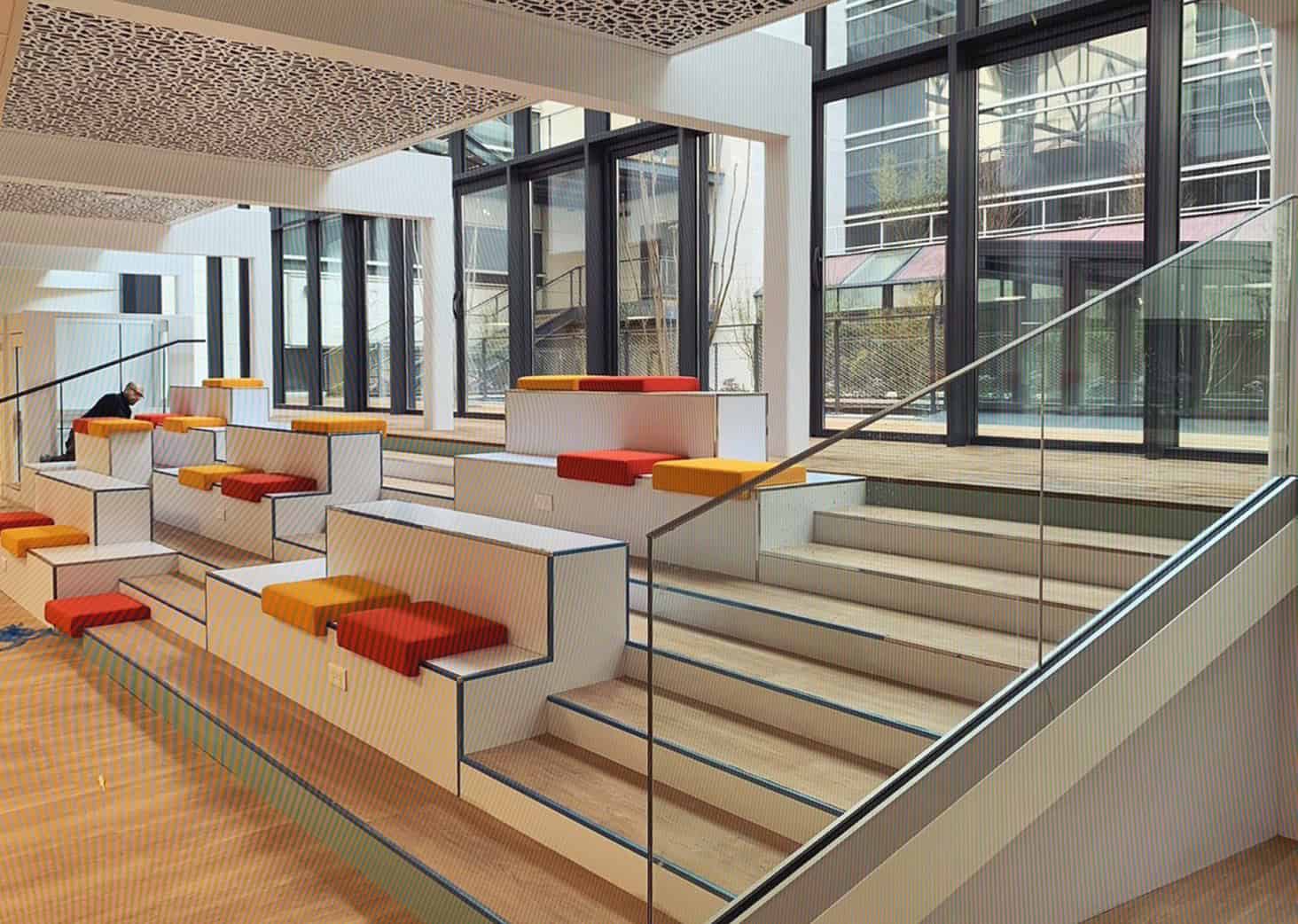 Espace lounge contemporain avec sièges colorés, grandes fenêtres et ambiance lumineuse, idéal pour d.