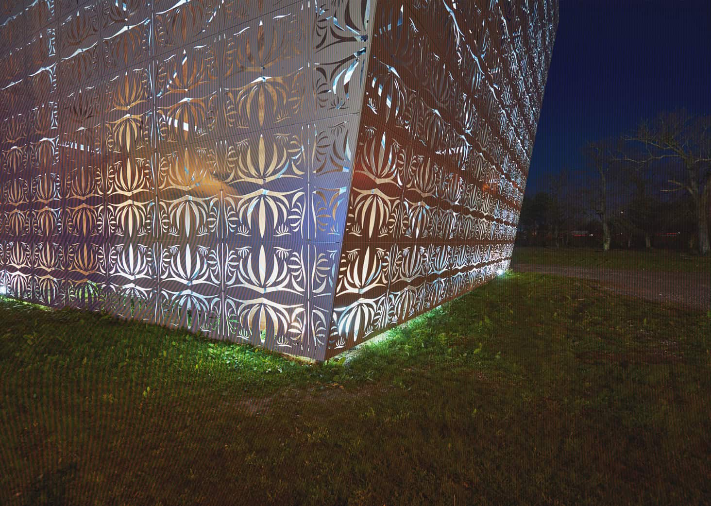 Vitrine architecturale moderne avec éclairage nocturne, design innovant et détails en métal perforé,.