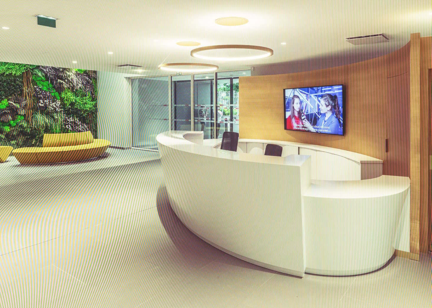 Espace d'accueil moderne avec mobilier élégant, mur végétal et écran d'information dans un bureau co.