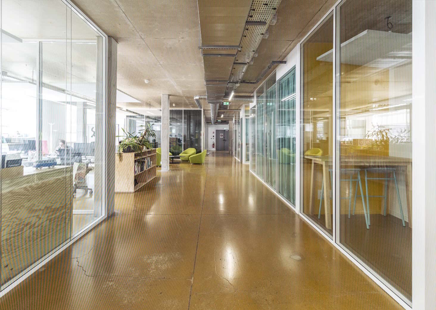 Bureau lumineux avec espaces de coworking modernes, murs en verre et mobilier contemporain dans un e.
