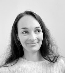 Portrait artistique en noir et blanc d'une femme souriante, mettant en valeur la créativité et l'exp.