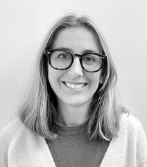 Portrait d'une femme souriante portant des lunettes, représentant la diversité urbaine et la moderni.